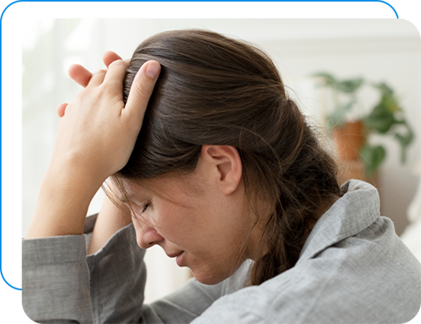 Woman in distraught with her hands on her head.