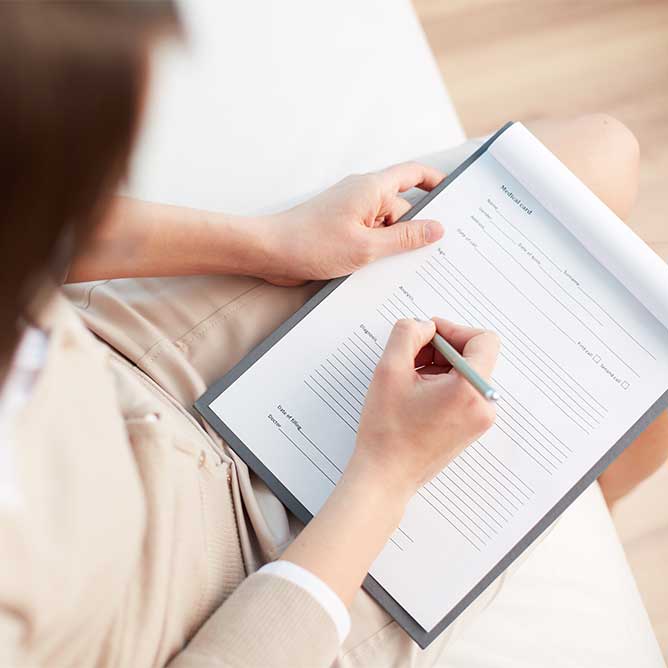 A person writing EMDR consultation notes on a clipboard.