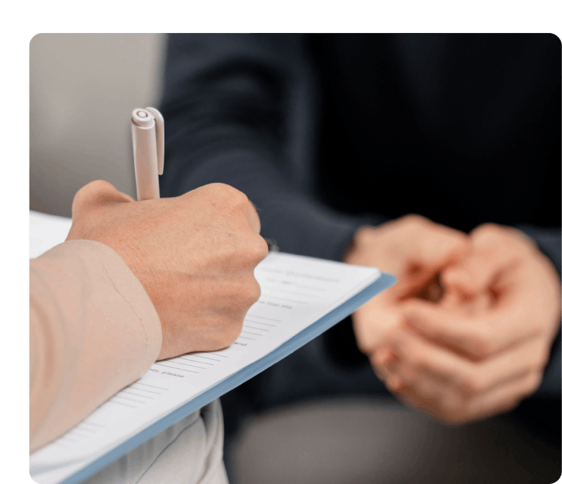 Health anxiety counselling session with therapist writing on a clipboard.