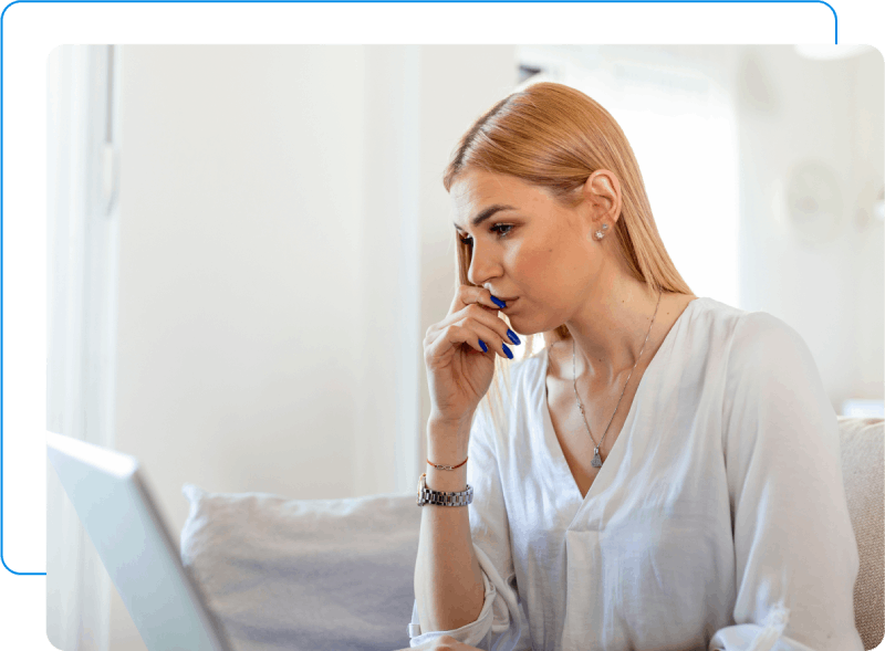 Woman looking at her computer with a stressed look.