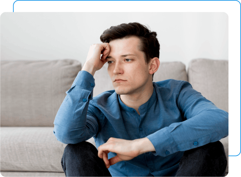 Man with health anxiety. facepalming while sitting on couch.