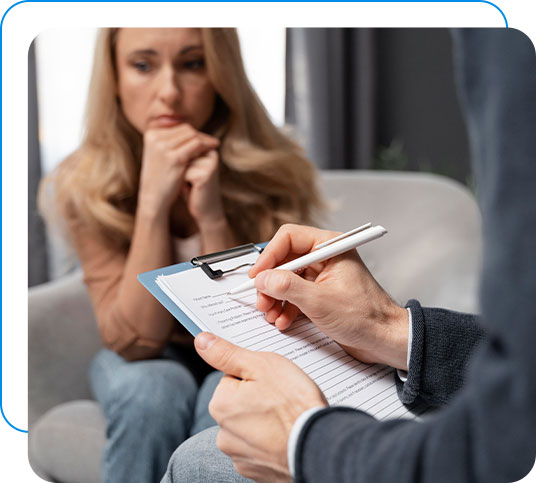 Woman looking worried while a depression psychologist writes notes.