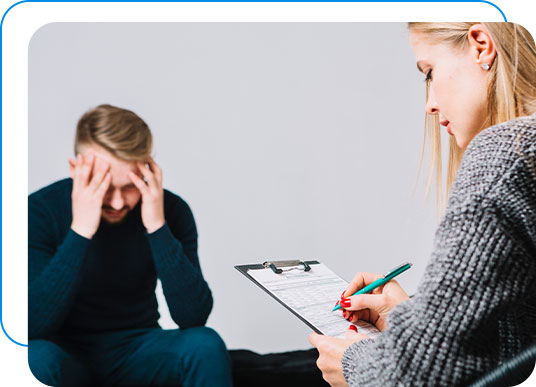 Man sitting across from a therapist taking notes in depression therapy.